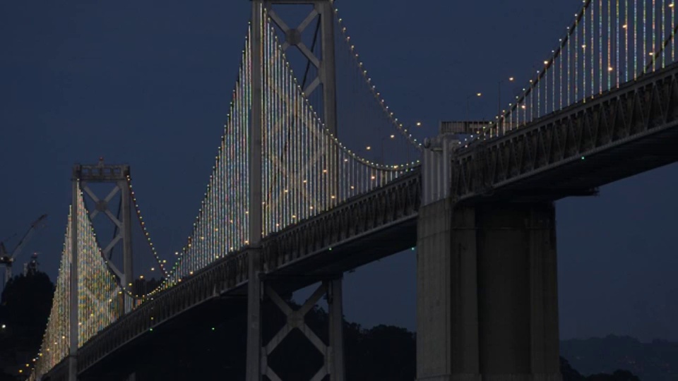 作为庆祝其75周年的独特艺术项目的一部分，海湾大桥的西跨安装了25000个LED灯，在接下来的两年里，这些灯将在夜间展示各种起伏的设计。视频下载