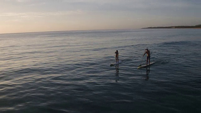 太阳升起的时候，一对夫妇在划船视频素材