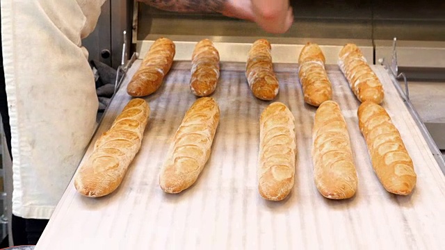 烘焙前，将长棍面包放在烤箱装载机上视频下载