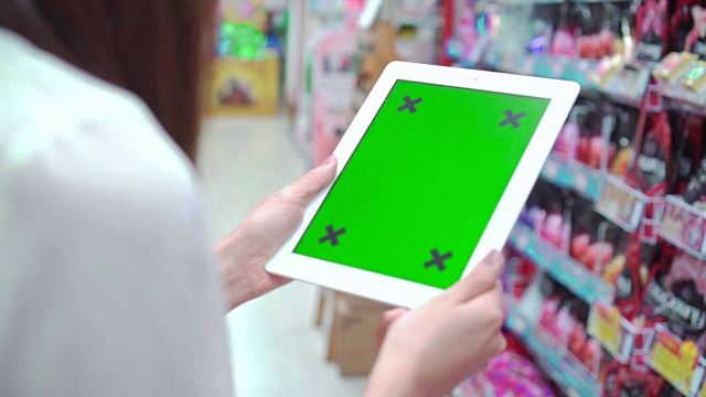 女人拿着空白平板电脑与绿色超市，特写视频下载