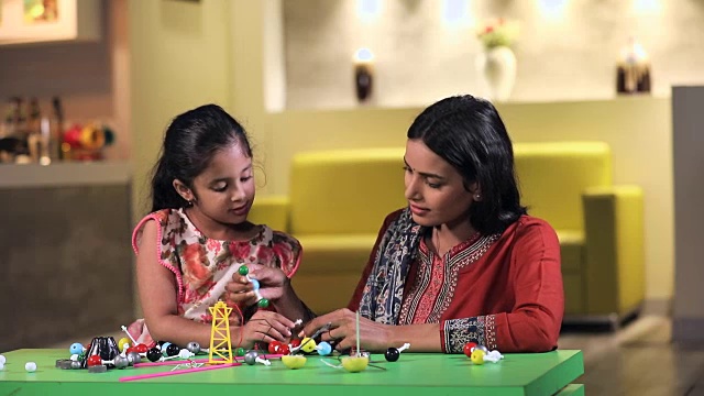 母亲帮助她的女儿在学校项目，德里，印度视频素材