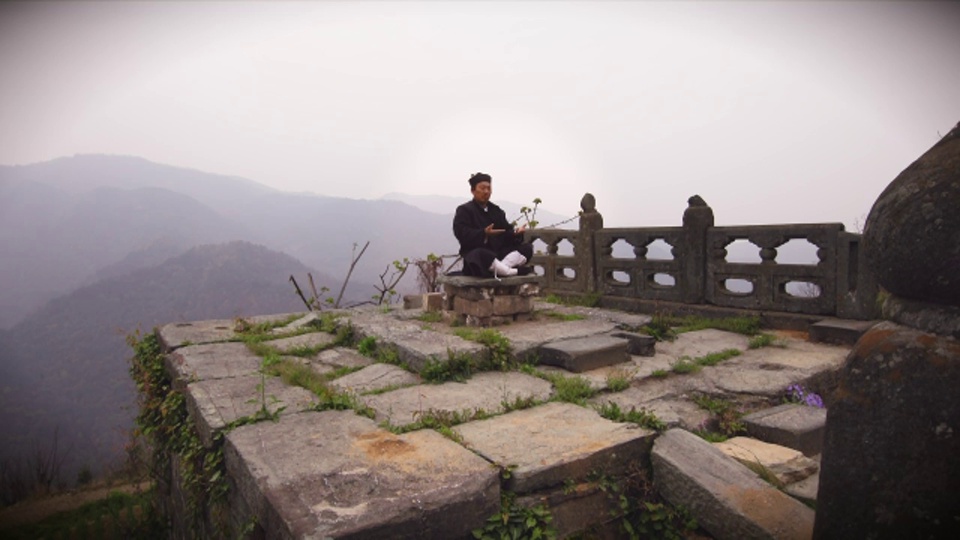 古武僧在迷雾缭绕的武当山遗址上冥想视频下载