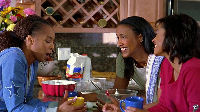 中号镜头拍摄了三个在厨房里拿着咖啡杯聊天的黑人妇女视频素材