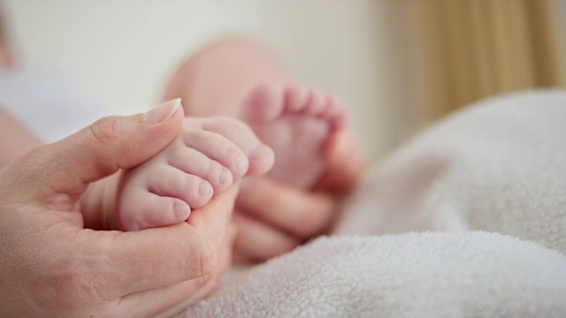 母亲的手抚摸着婴儿的脚视频下载