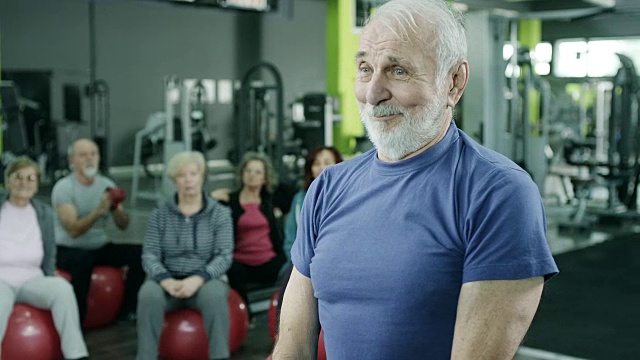 一个带着水壶铃声健身的老男人视频素材