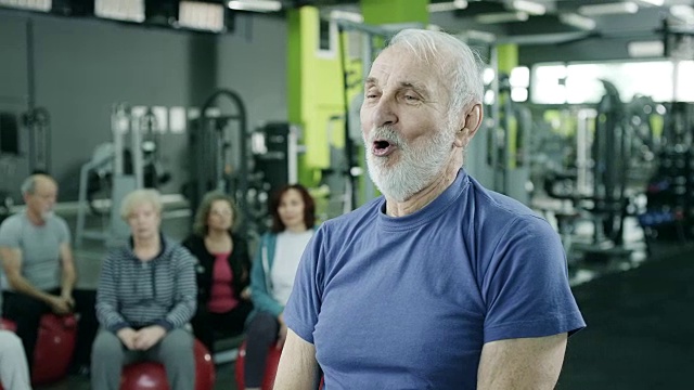 一个带着水壶铃声健身的老男人视频素材