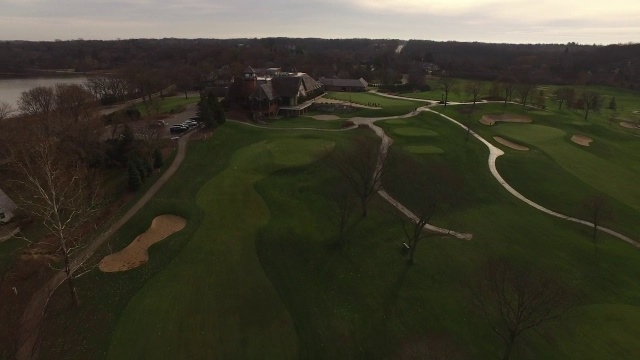 在秋天的一天，空中沿着高尔夫球场向俱乐部会所缓慢滑行视频下载