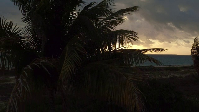 在墨西哥坎昆的海面上，随着夕阳的微光，空中低垂视频素材