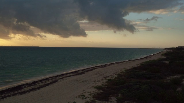 在日落时分，墨西哥坎昆沿着水边飞向大海视频素材