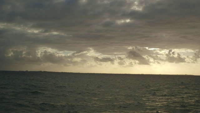 在墨西哥坎昆的夕阳下，在黑暗平静的海洋上空视频素材