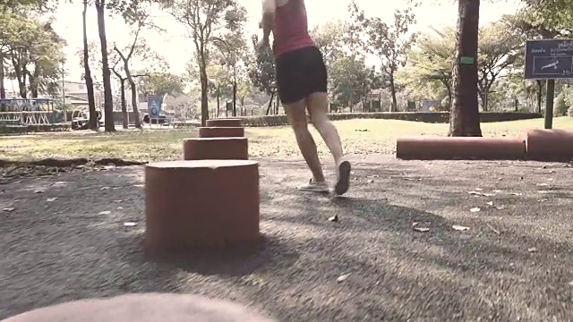 女人在公园里的红木周围奔跑的慢动作视频下载