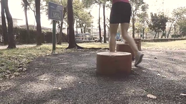 女人在公园里的红木周围奔跑的慢动作视频下载