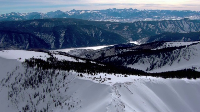 雪依附在山的侧面和山峰上。视频下载