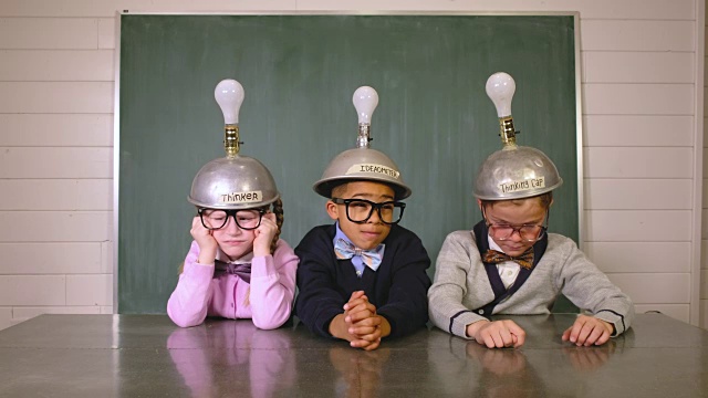 年轻的书呆子们戴着创意头盔思考视频下载