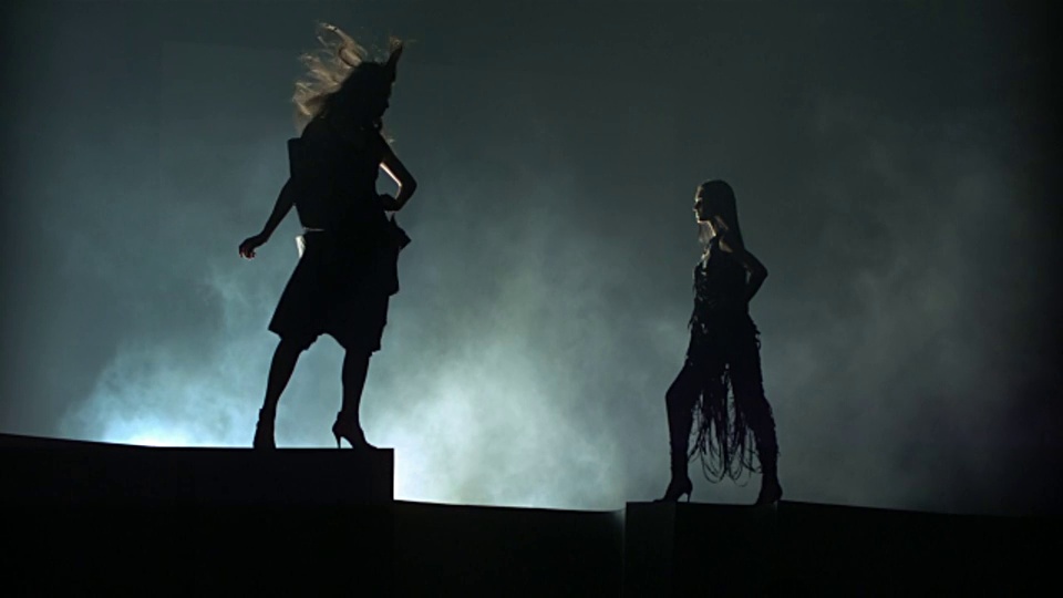 两个女人侧影站在舞台上，风吹着她们的头发和衣服。视频下载
