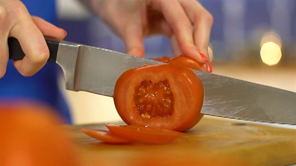 女性用手切西红柿，慢镜头视频素材
