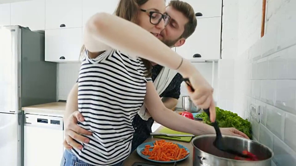 幸福的年轻夫妇喜欢做饭。视频素材