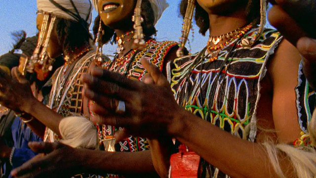 中拍沃达贝人穿着传统服装和脸上涂着彩绘在户外婚礼上鼓掌/尼日尔视频素材