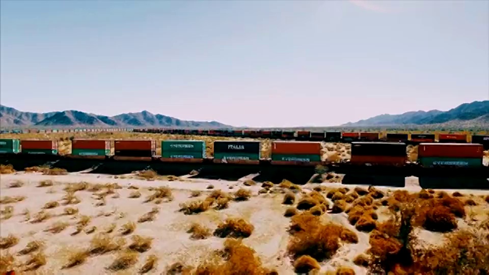 无人机拍摄的画面显示，在美国沙漠中部，一列移动的集装箱火车沿着一条铁路飞速行驶。视频下载