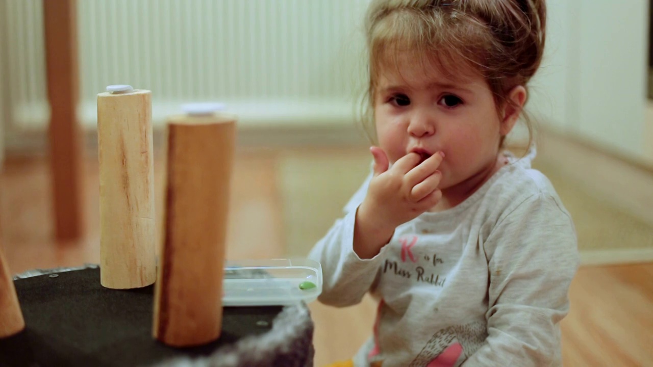 小女孩在吃五颜六色的巧克力糖视频素材
