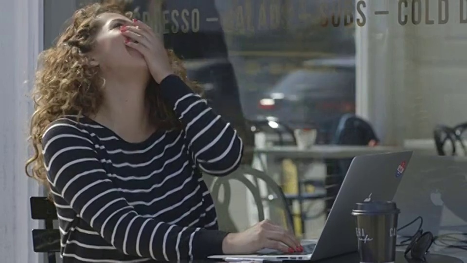 咖啡馆-年轻女子在笔记本电脑上视频素材