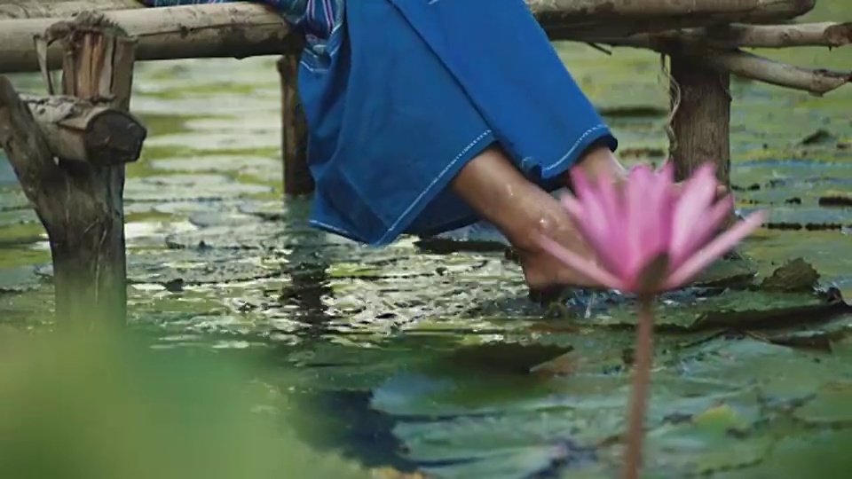 缅甸少女湿她的脚在一个池塘视频素材