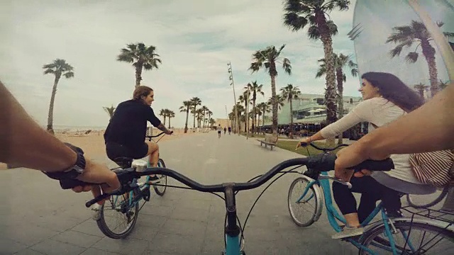 和朋友们在西班牙巴塞罗那的巴塞罗那海滩上骑自行车视频素材
