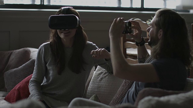 男友用虚拟现实头盔拍摄女友视频素材