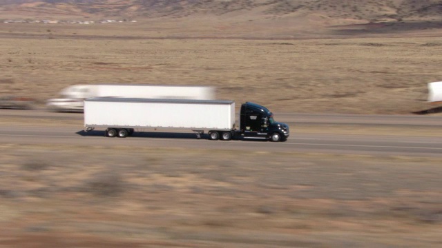 一辆半挂车在沙漠公路上行驶。视频下载