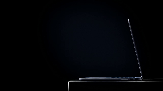 打开笔记本电脑，键盘和屏幕背景上投射出蓝光视频下载
