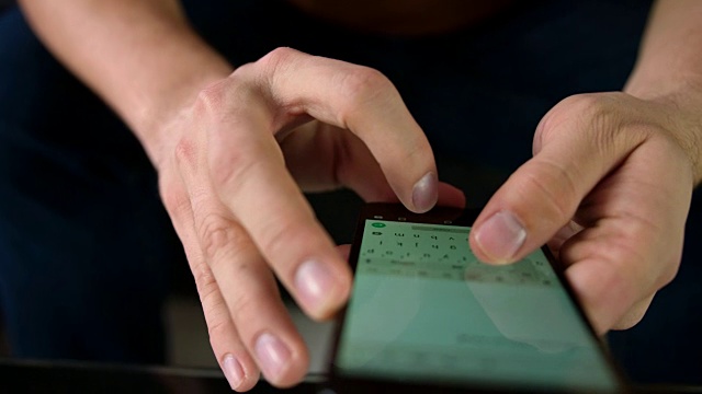 多莉拍摄了一个男人用他的智能手机写电子邮件视频素材