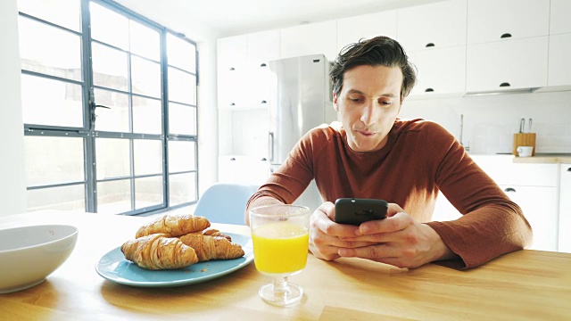 边吃早餐边使用手机。视频素材