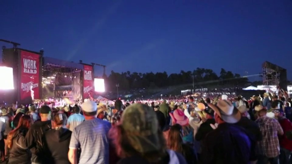 一群人围在“靴子与心”音乐节的舞台上。视频下载