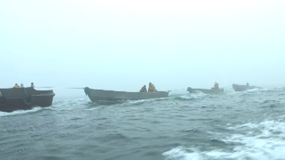 一艘大船在雾中拖着渔船。视频下载