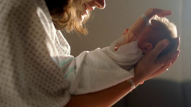 近女人抱着并与哭泣的新生儿交谈视频下载