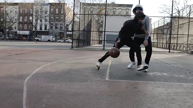 两个二十多岁的年轻人在纽约布鲁克林一个寒冷的早晨打篮球——4k视频下载