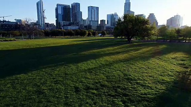 太阳在树之间巴特勒公园在奥斯汀德克萨斯州日出的第一天，由西南偏南鸟瞰首都周围的城市视频下载