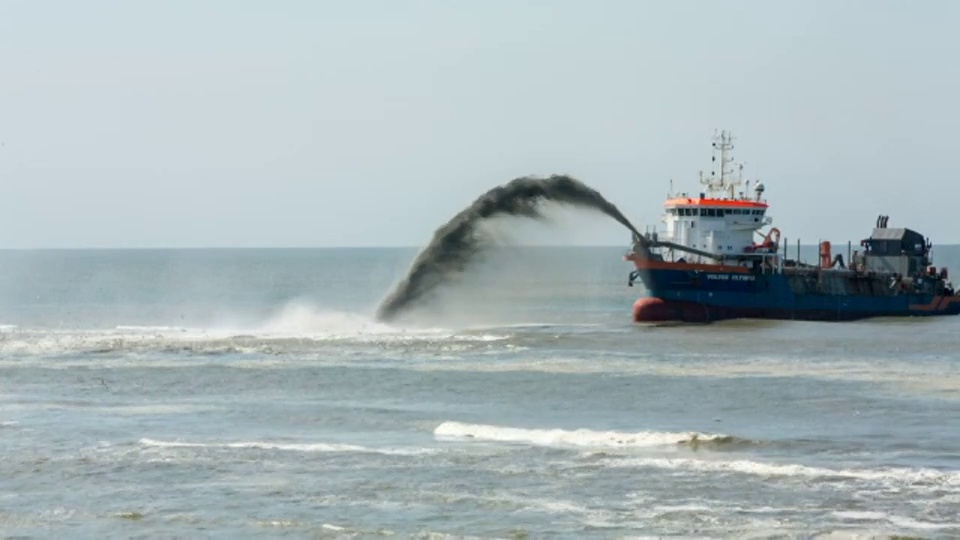 荷兰，Petten，加固海堤称为Hondsbossche Zeewering。一种耙吸式挖泥船正在堤前积沙视频素材