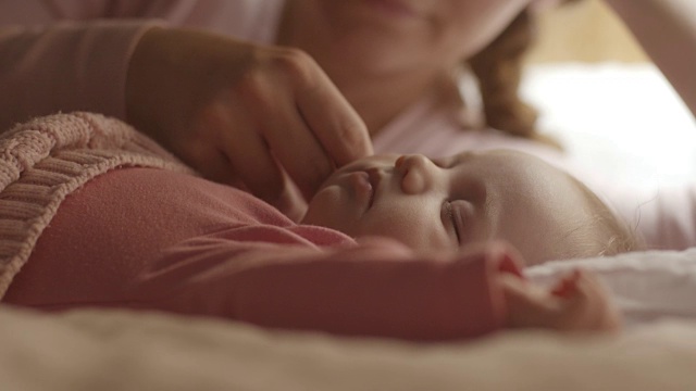 母亲抚摸着女婴的脸颊视频素材