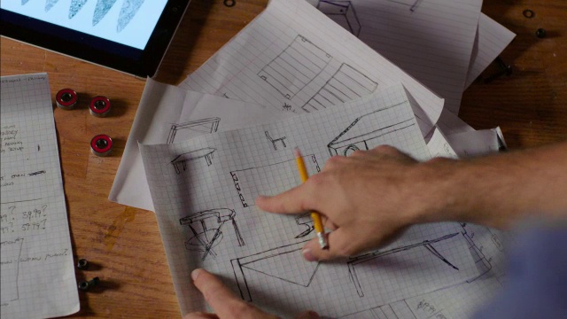工作人员在图纸和平板电脑上指出家具设计元素视频素材