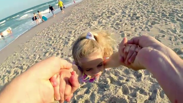 可爱的小女孩笑着，爸爸在阳光沙滩上荡秋千视频素材