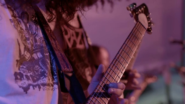 重金属乐队演奏吉他，用慢镜头和谐地撞击他们的头部视频下载