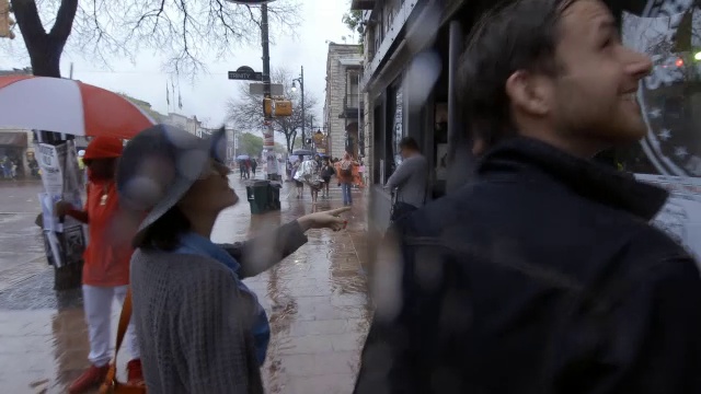 一对迷路的年轻夫妇在雨中漫步穿过奥斯汀市中心视频素材