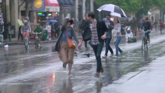 一对年轻夫妇在雨中跑过马路视频素材