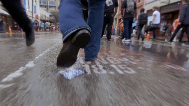 人们在雨中穿过奥斯汀拥挤的街道视频素材