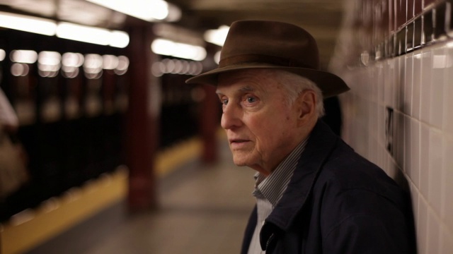 MED侧面的老人在地铁站台上望着窗外经过的列车，抽着鼻子等待视频素材