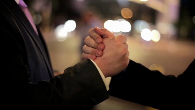 在拉斯维加斯的长街上，两个商人互相冷握手。视频下载