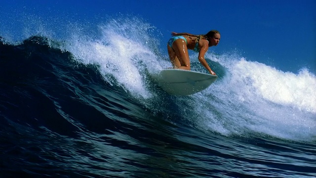 慢动作宽镜头女性冲浪者骑在波浪之字形/塔希提视频素材