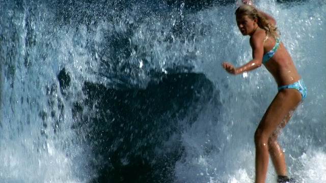 慢动作中镜头女冲浪者向后落下冲浪板/大溪地视频素材