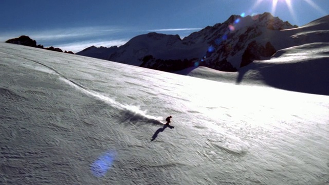 空中WS TS滑雪者移动的斜坡与山脉和阳光在背景/瑞士视频素材